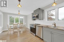 Kitchen with a wealth of natural light, appliances with stainless steel finishes, and decorative light fixtures - 