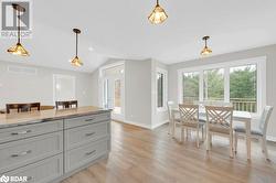 Kitchen with pendant lighting, plenty of natural light, light hardwood / wood-style floors, and vaulted ceiling - 