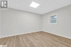 Empty room featuring a drop ceiling and light hardwood / wood-style floors - 