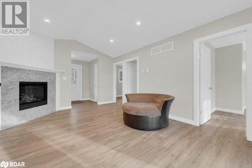 Living area featuring light wood-type flooring, lofted ceiling, and a premium fireplace - 530 Addington Road 5, Cloyne, ON - Indoor Photo Showing Living Room With Fireplace