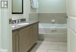 Bathroom with a bath, vanity, and tile patterned floors - 