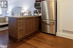 Kitchen with kitchen peninsula, dark hardwood / wood-style floors, sink, and appliances with stainless steel finishes - 