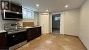 Kitchen featuring light stone countertops, dark brown cabinets, sink, and appliances with stainless steel finishes - 406 Erb Street W Unit# 2, Waterloo, ON  - Indoor Photo Showing Kitchen 