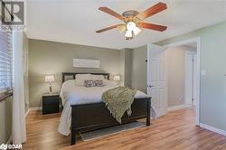 Bedroom with a textured ceiling, wood-type flooring, and ceiling fan - 