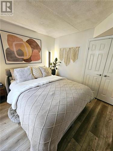 Bedroom featuring a closet, a textured ceiling, and dark hardwood / wood-style floors - 2030 Cleaver Avenue Unit# 122, Burlington, ON - Indoor Photo Showing Bedroom