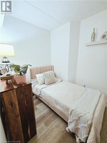 Bedroom featuring hardwood / wood-style floors and a textured ceiling - 2030 Cleaver Avenue Unit# 122, Burlington, ON - Indoor Photo Showing Bedroom