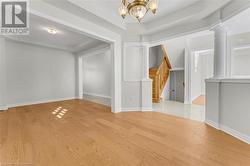 Empty room with light hardwood / wood-style floors and a notable chandelier - 