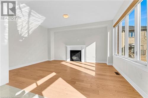 Unfurnished living room featuring a wealth of natural light and light hardwood / wood-style flooring - 1174 Upper Thames Drive, Woodstock, ON - Indoor Photo Showing Living Room With Fireplace