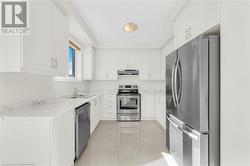 Kitchen with stainless steel appliances, white cabinets, and sink - 