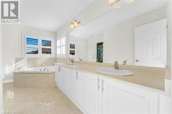 Bathroom with vanity, a relaxing tiled tub, and tile patterned flooring - 