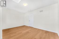 Unfurnished room with light wood-type flooring and a skylight - 