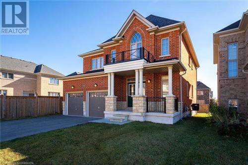 View of front of house featuring a garage, a front yard, and a porch - 1174 Upper Thames Drive, Woodstock, ON - Outdoor With Deck Patio Veranda