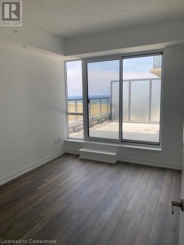 Spare room with a water view, dark wood-type flooring, and a textured ceiling - 550 North Service Road Unit# 1001, Grimsby, ON - Indoor Photo Showing Other Room