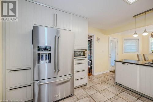 Kitchen featuring white cabinetry, stainless steel appliances, light tile patterned floors, and pendant lighting - 2378 Headon Road, Burlington, ON - Indoor Photo Showing Kitchen With Stainless Steel Kitchen