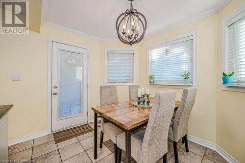 Tiled dining area featuring a notable chandelier and crown molding - 2378 Headon Road, Burlington, ON - Indoor Photo Showing Dining Room