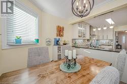 Dining area with a chandelier, sink, and crown molding - 