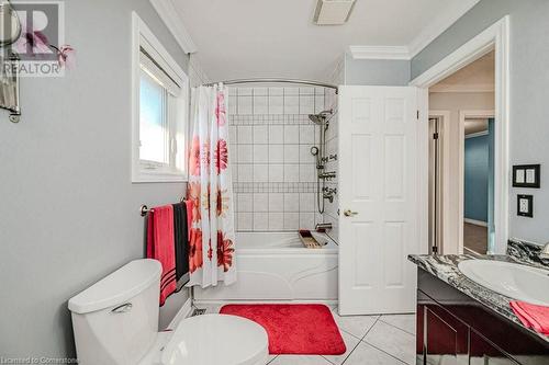 Full bathroom featuring tile patterned flooring, ornamental molding, vanity, shower / bath combo, and toilet - 2378 Headon Road, Burlington, ON - Indoor Photo Showing Bathroom