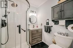 Updated Bathroom featuring crown molding, an enclosed shower, vanity, and toilet - 