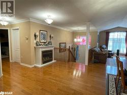 Living room with hardwood / wood-style floors, ornamental molding, and a textured ceiling - 