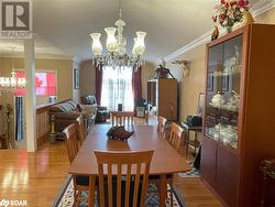 Dining room featuring an inviting chandelier, wood-type flooring, and ornamental molding - 