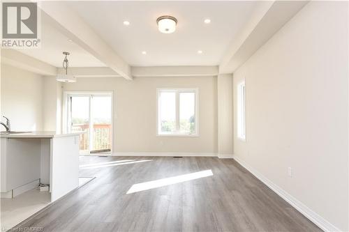 Unfurnished living room with beamed ceiling, a healthy amount of sunlight, sink, and light wood-type flooring - 620 Colborne Street W Unit# 42, Brantford, ON - Indoor Photo Showing Other Room