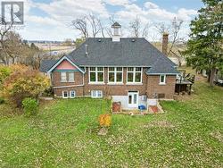 Rear view of house featuring a wooden deck and a yard - 