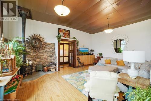 Living room featuring a wood stove and hardwood / wood-style floors - 687 Highway 6 Highway, Caledonia, ON - Indoor Photo Showing Living Room With Fireplace