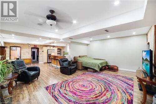 Bedroom with hardwood / wood-style flooring, ceiling fan, stainless steel fridge, and a tray ceiling - 687 Highway 6 Highway, Caledonia, ON - Indoor