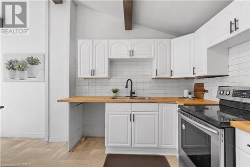 Kitchen with white cabinets, wood counters, and stainless steel range with electric stovetop - 233 Nile Street, Stratford, ON - Indoor Photo Showing Kitchen With Double Sink