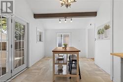 Dining area featuring a chandelier and vaulted ceiling with beams - 