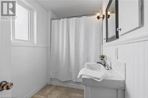 Bathroom with shower / bath combo, vanity, and hardwood / wood-style floors - 233 Nile Street, Stratford, ON - Indoor Photo Showing Bathroom