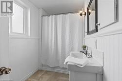 Bathroom with shower / bath combo, vanity, and hardwood / wood-style floors - 