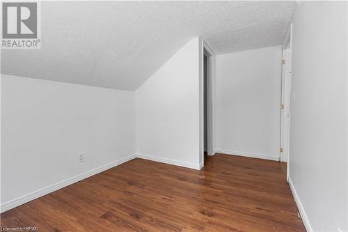 Bonus room with dark hardwood / wood-style flooring, vaulted ceiling, and a textured ceiling - 233 Nile Street, Stratford, ON - Indoor Photo Showing Other Room