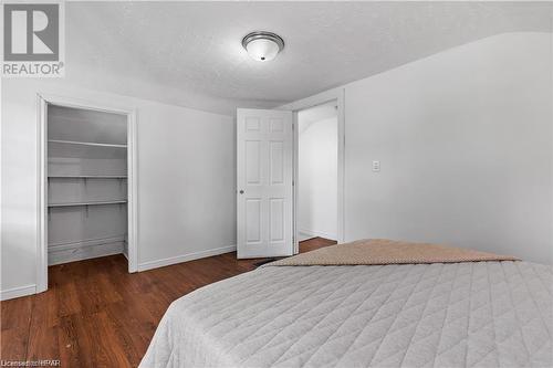 Bedroom featuring dark hardwood / wood-style flooring and a textured ceiling - 233 Nile Street, Stratford, ON - Indoor Photo Showing Bedroom