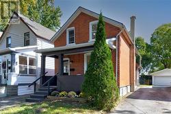 Front of property featuring a garage and an outdoor structure - 