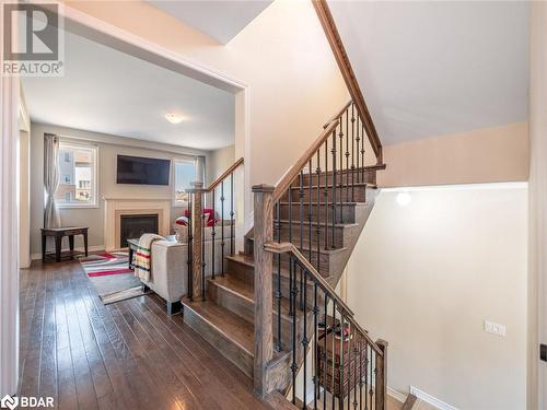 Stairway featuring hardwood / wood-style floors - 3046 Stone Ridge Boulevard, Orillia, ON - Indoor Photo Showing Other Room With Fireplace