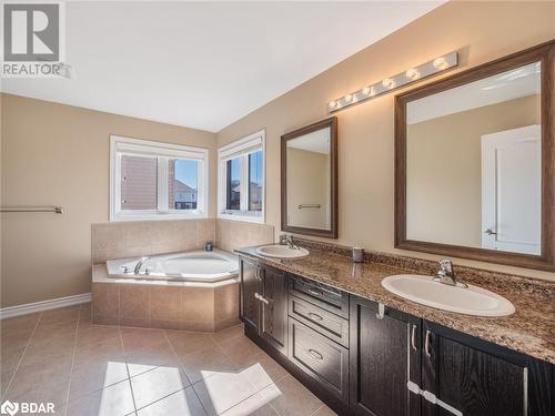 Bathroom featuring tiled bath, tile patterned flooring, and vanity - 3046 Stone Ridge Boulevard, Orillia, ON - Indoor Photo Showing Bathroom