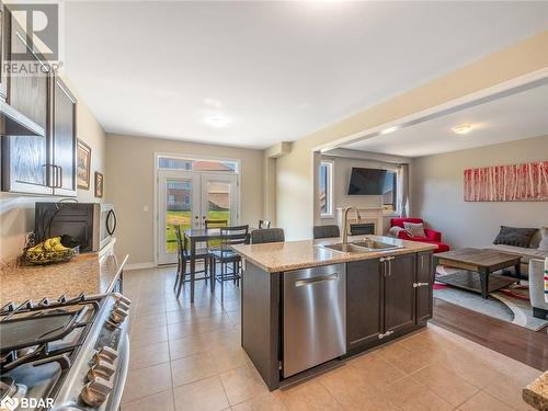 Kitchen with appliances with stainless steel finishes, sink, dark brown cabinetry, and light tile patterned floors - 3046 Stone Ridge Boulevard, Orillia, ON - Indoor