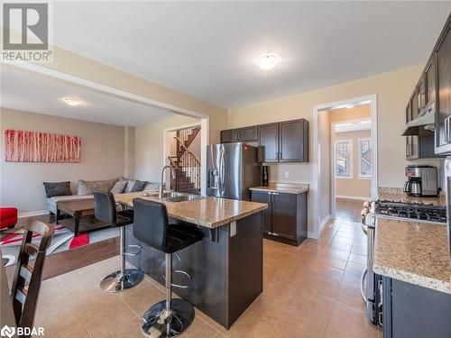 Kitchen featuring stainless steel appliances, a kitchen bar, light hardwood / wood-style flooring, sink, and a kitchen island with sink - 3046 Stone Ridge Boulevard, Orillia, ON - Indoor Photo Showing Kitchen With Stainless Steel Kitchen