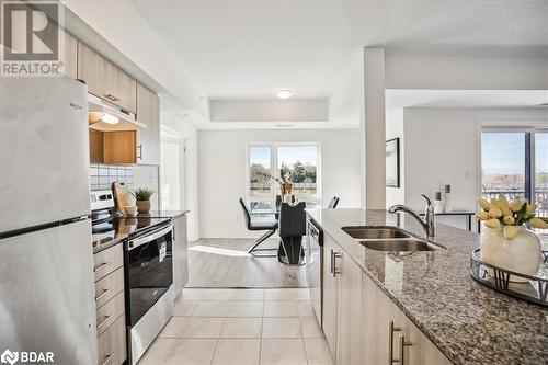 Kitchen featuring light hardwood / wood-style floors, light stone counters, plenty of natural light, sink, and appliances with stainless steel finishes - 8 Culinary Lane Unit# 402, Barrie, ON - Indoor Photo Showing Kitchen With Double Sink With Upgraded Kitchen