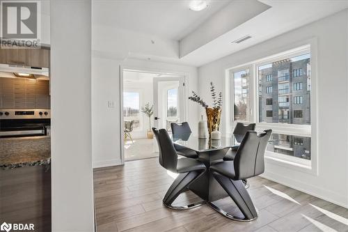 Dining space with light hardwood / wood-style floors and a raised ceiling - 8 Culinary Lane Unit# 402, Barrie, ON - Indoor Photo Showing Dining Room