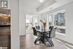 Dining space with light hardwood / wood-style floors and a raised ceiling - 