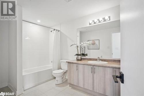 Full bathroom featuring tile patterned floors, vanity, shower / bath combo with shower curtain, and toilet - 8 Culinary Lane Unit# 402, Barrie, ON - Indoor Photo Showing Bathroom