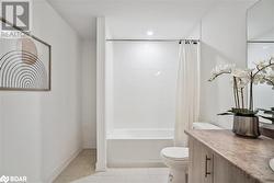 Full bathroom with shower / bath combo, tile patterned flooring, vanity, and toilet - 