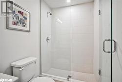 Bathroom featuring toilet and a shower with shower door - 