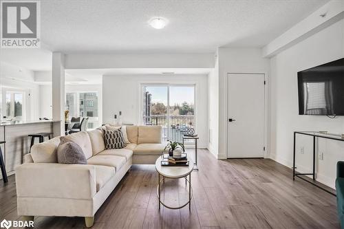 Living room featuring light hardwood / wood-style floors and a textured ceiling - 8 Culinary Lane Unit# 402, Barrie, ON - Indoor Photo Showing Living Room