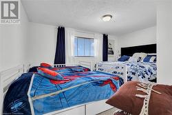 Bedroom featuring a textured ceiling and carpet floors - 