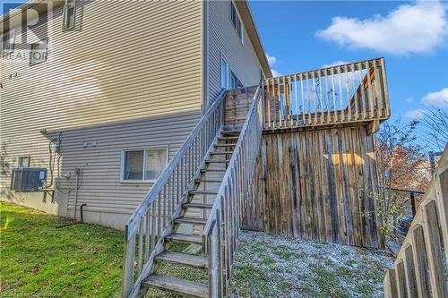 View of side of home featuring central AC and a lawn - 50 Howe Drive Unit# 17B, Kitchener, ON - Outdoor With Exterior