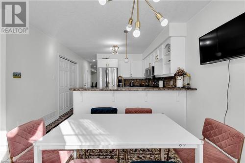 Dining area with a notable chandelier and a textured ceiling - 50 Howe Drive Unit# 17B, Kitchener, ON - Indoor