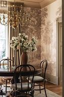 Dining room with wood-type flooring, crown molding, and an inviting chandelier - 